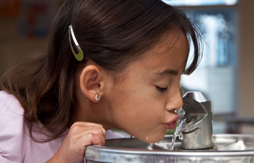 girl drinking from water fountain image